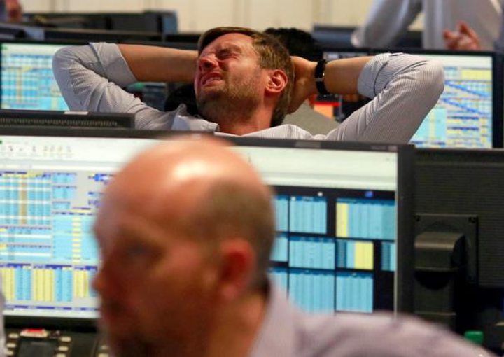 A trader from BGC, a global brokerage company in London's Canary Wharf financial centre reacts...