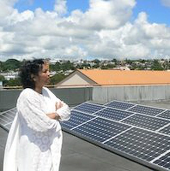 Andrea Gungadin on the roof with her solar panels