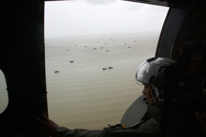 An Indonesian navy crew member searched for parts of AirAsia Flight 8501 above the Karimata Strait.