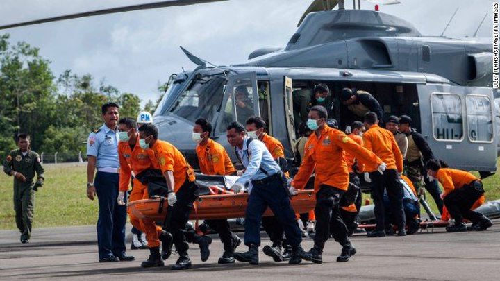 Members of a search and rescue team carry the body of a victim of AirAsia Flight QZ8501 at Iskandar 