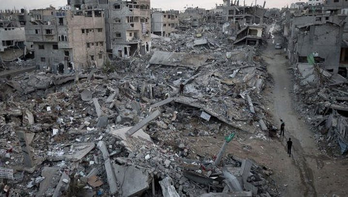 Palestinians walk through rubble of destroyed homes and buildings from the 50-day conflict