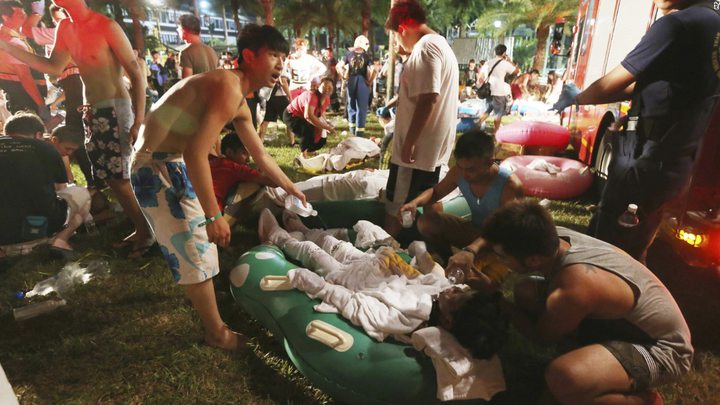 Emergency rescue workers and concert spectators tend to injured victims from an explosion during