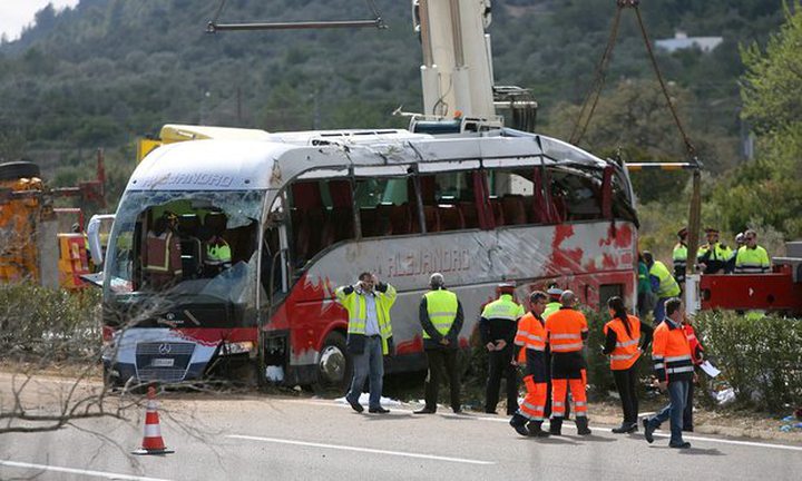 Rescue workers remove the coach after a crash on the AP-7 motorway in the province of Tarragona