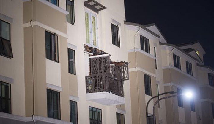 A fourth floor balcony rests on the balcony below after collapsing at the Library Gardens apartment 