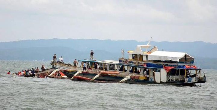 Passengers of the capsized MBCA Kim-Nirvana ferry (far L) are rescued by a tugboat of the Philippine