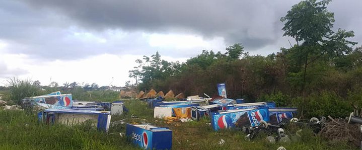 Réfrigérateurs Pepsi entassés sur un terrain vague