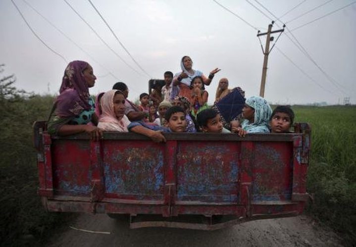 Indian villagers sit in a tractor trolley as they move to safer places at Devi Garh village ..